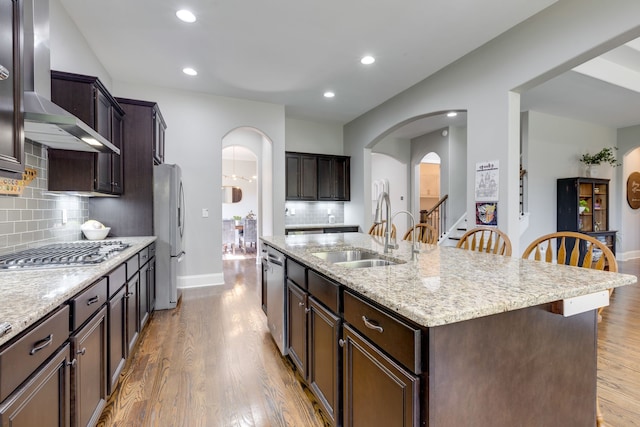 kitchen featuring appliances with stainless steel finishes, sink, a kitchen breakfast bar, hardwood / wood-style flooring, and a kitchen island with sink