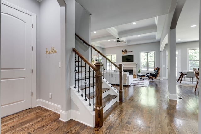 entryway with a wealth of natural light, hardwood / wood-style floors, beam ceiling, and coffered ceiling