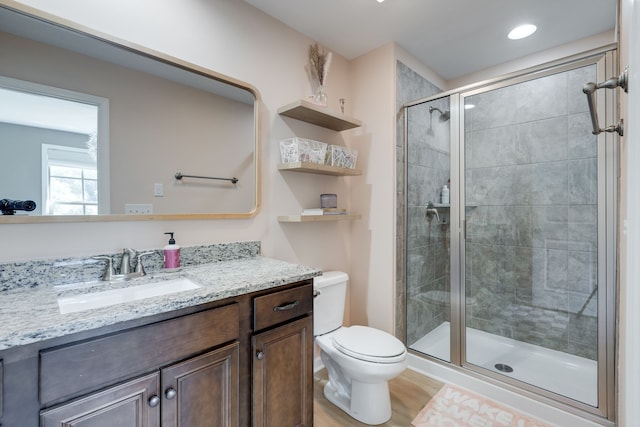 bathroom with vanity, toilet, an enclosed shower, and hardwood / wood-style floors