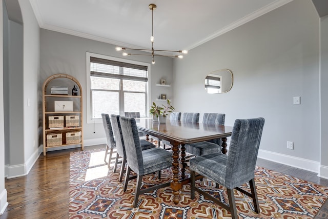 dining space featuring ornamental molding, a chandelier, and dark hardwood / wood-style flooring