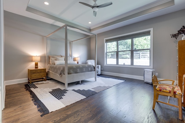 bedroom with dark wood-type flooring, a raised ceiling, crown molding, and ceiling fan