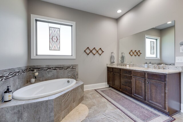 bathroom with vanity and tiled tub