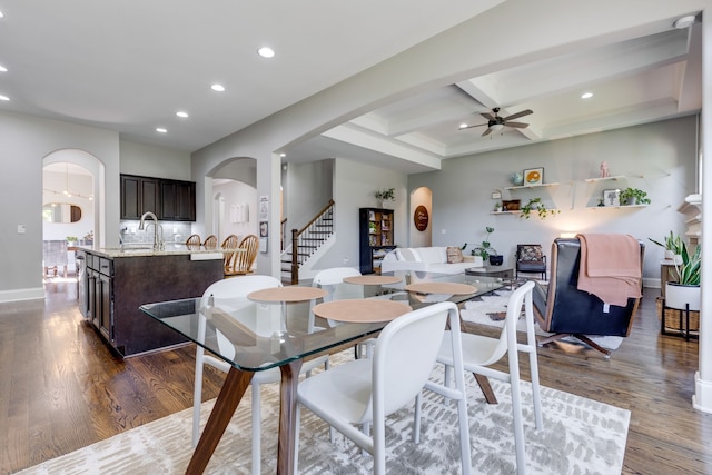 dining space with sink, ceiling fan, coffered ceiling, beam ceiling, and dark hardwood / wood-style floors