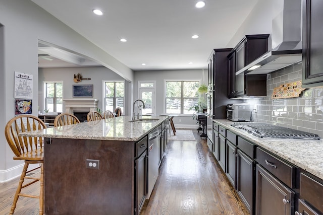 kitchen featuring an island with sink, hardwood / wood-style flooring, a kitchen bar, stainless steel appliances, and sink