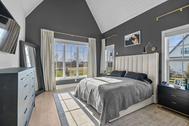 bedroom featuring light hardwood / wood-style flooring, multiple windows, high vaulted ceiling, and wood ceiling