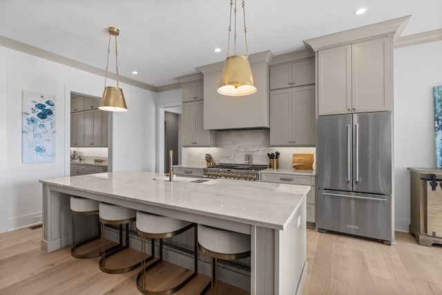 kitchen with gray cabinetry, light hardwood / wood-style floors, stainless steel appliances, and a spacious island