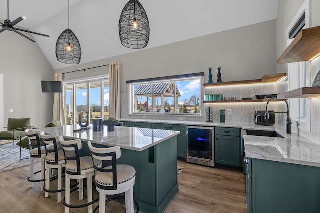 kitchen with hardwood / wood-style floors, beverage cooler, ceiling fan, sink, and decorative light fixtures