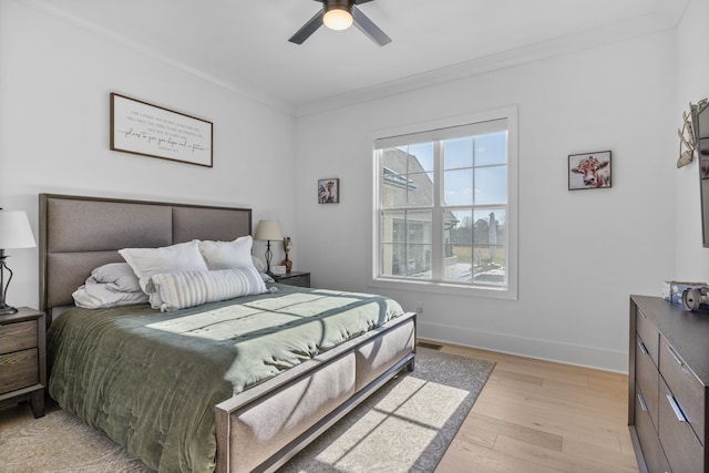 bedroom with light hardwood / wood-style flooring, crown molding, and ceiling fan