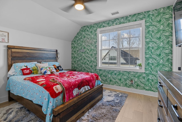 bedroom with lofted ceiling, hardwood / wood-style floors, and ceiling fan