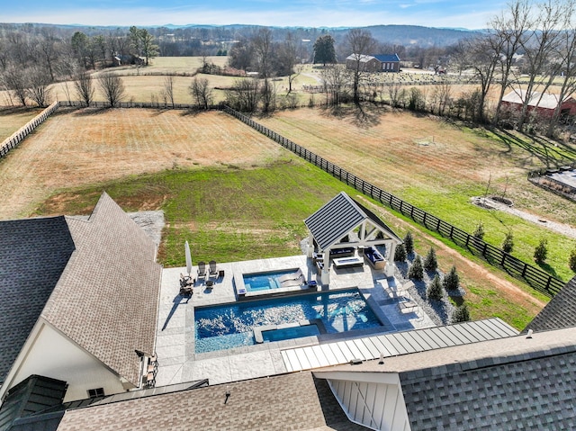 view of swimming pool with a patio area, a yard, and a rural view