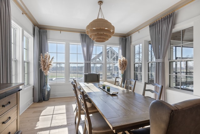 dining area featuring crown molding and light wood-type flooring