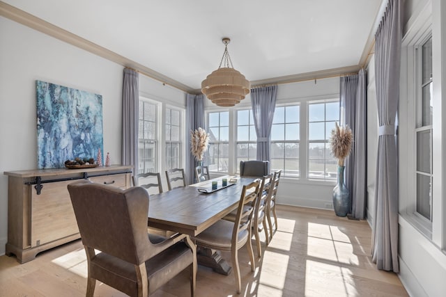 dining space with light hardwood / wood-style floors and ornamental molding