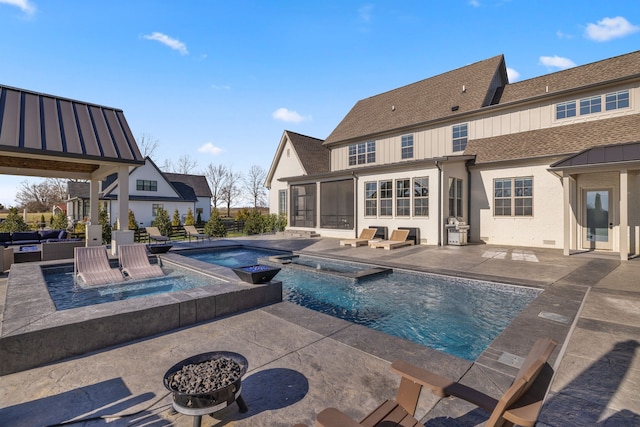 view of pool with a patio, an in ground hot tub, and an outdoor fire pit