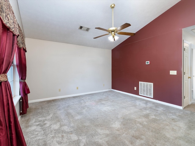 empty room featuring lofted ceiling, carpet flooring, and ceiling fan