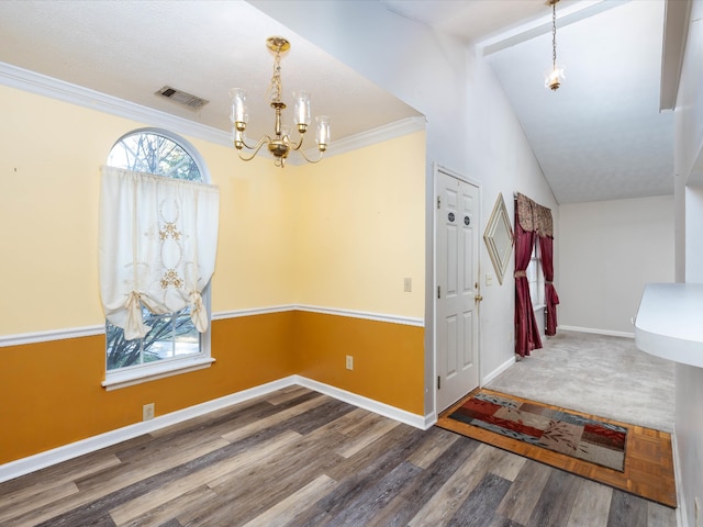 foyer featuring ornamental molding, dark wood-type flooring, vaulted ceiling, and a notable chandelier