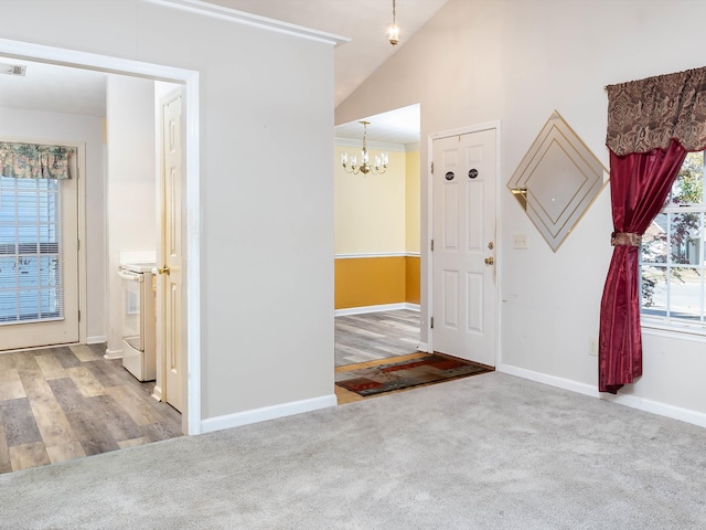 entrance foyer featuring a notable chandelier, vaulted ceiling, and carpet floors