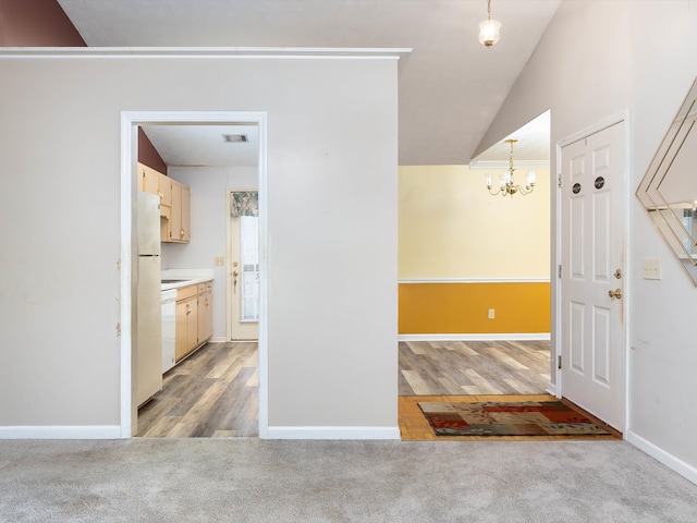 interior space featuring an inviting chandelier, light wood-type flooring, and vaulted ceiling