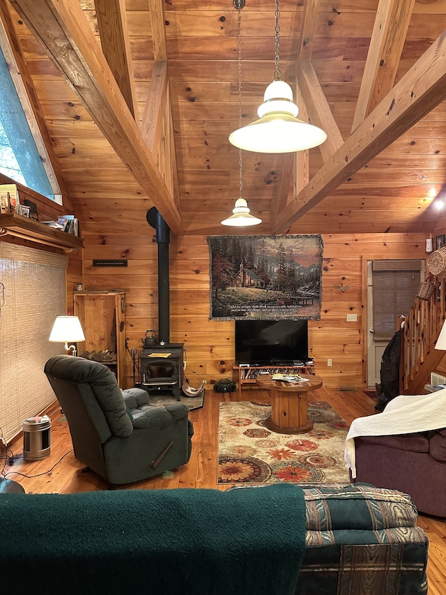 living room featuring vaulted ceiling with beams, wood walls, wooden ceiling, and wood-type flooring