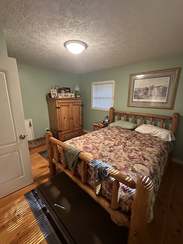 bedroom featuring wood-type flooring and a textured ceiling