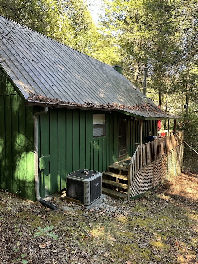 back of house featuring central air condition unit and a deck