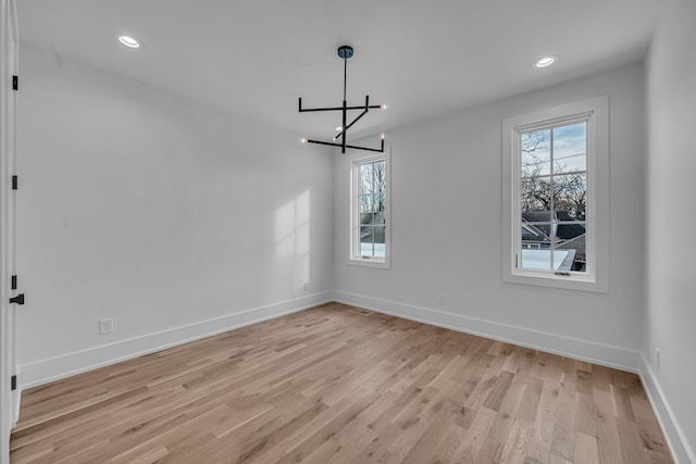 unfurnished dining area with an inviting chandelier, a healthy amount of sunlight, and light wood-type flooring