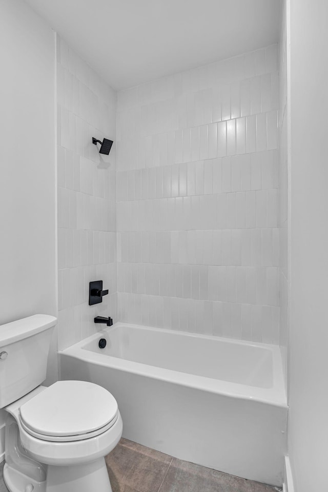 bathroom featuring tiled shower / bath and toilet