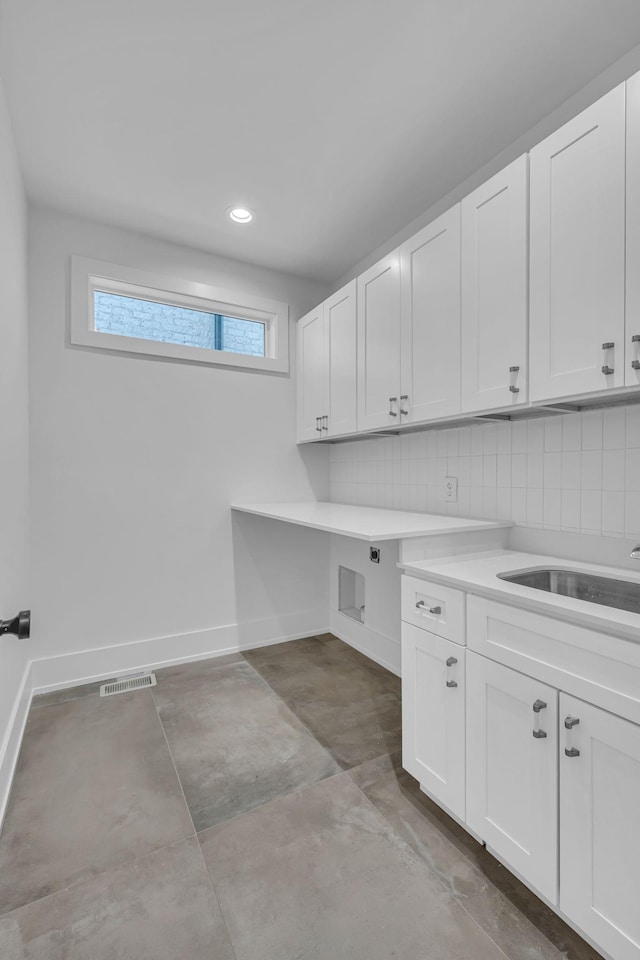 washroom featuring cabinets, electric dryer hookup, and sink