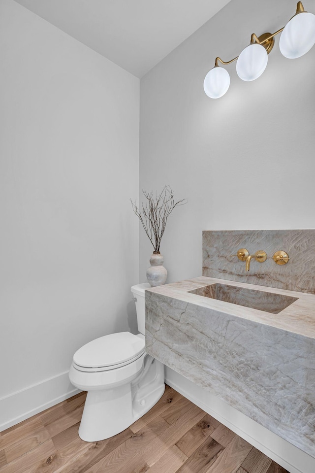 bathroom with toilet, sink, and hardwood / wood-style floors