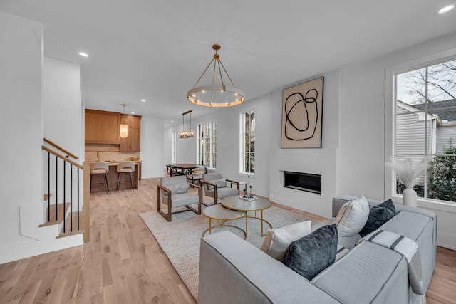 living room featuring an inviting chandelier and light wood-type flooring