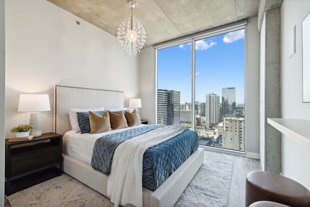 bedroom featuring an inviting chandelier and light wood-type flooring