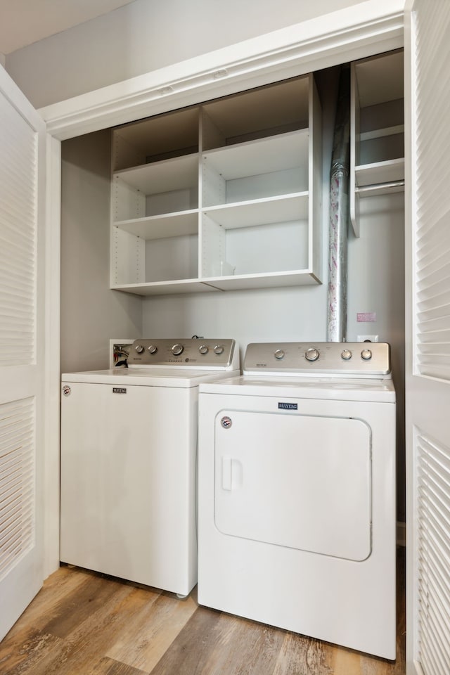 laundry area with separate washer and dryer and light wood-type flooring