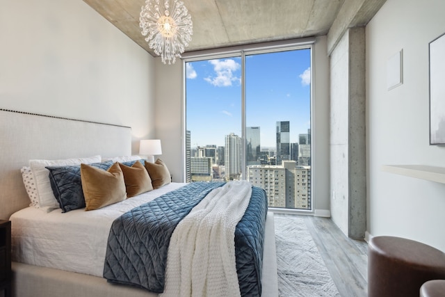 bedroom featuring an inviting chandelier and light hardwood / wood-style floors