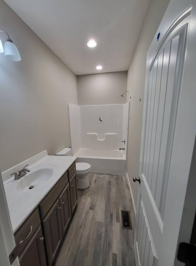 full bathroom featuring toilet, tub / shower combination, vanity, and hardwood / wood-style flooring