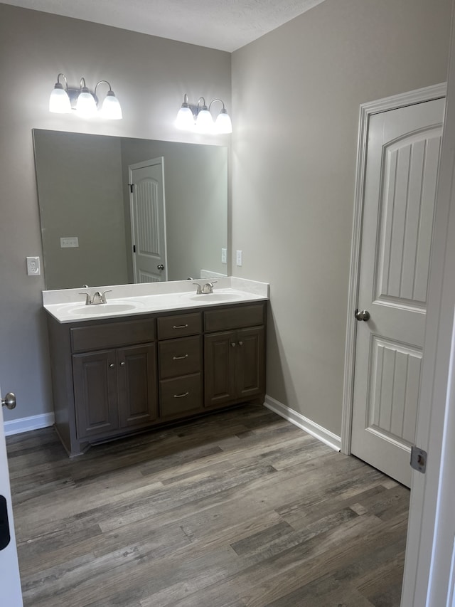 bathroom featuring hardwood / wood-style floors, vanity, and a textured ceiling