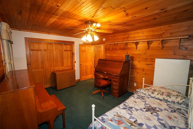 bedroom featuring wood walls, a closet, ceiling fan, wooden ceiling, and dark colored carpet