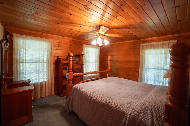 carpeted bedroom featuring wooden walls, wood ceiling, and multiple windows