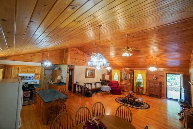 dining room featuring wood walls, vaulted ceiling, light hardwood / wood-style floors, and wooden ceiling