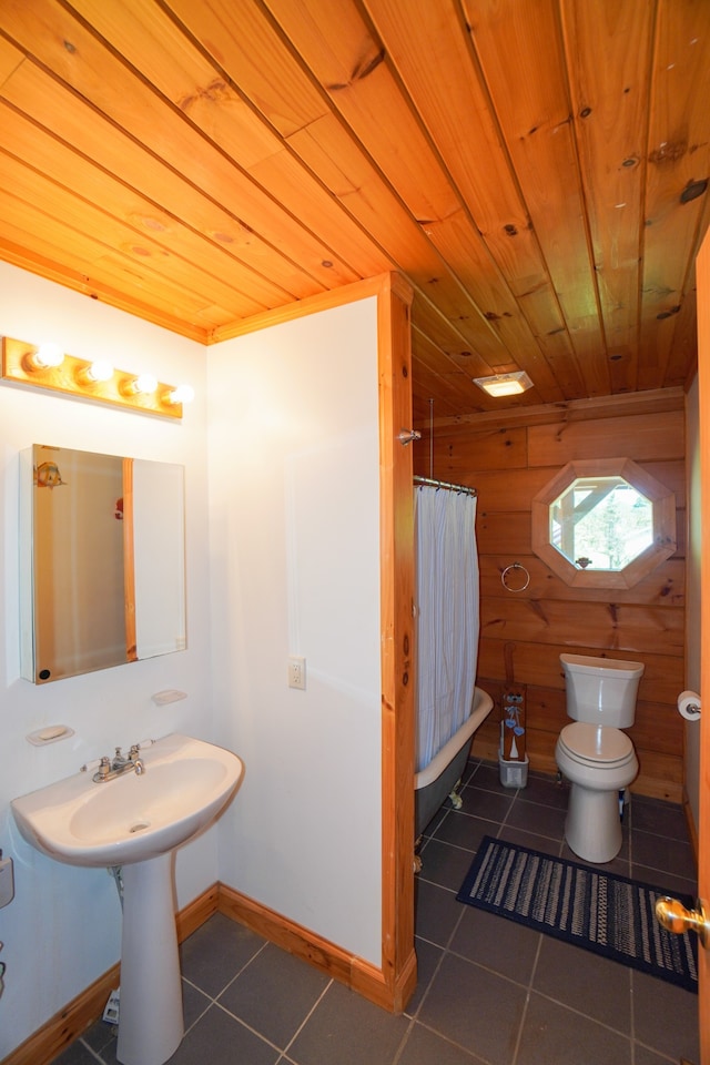 bathroom featuring toilet, walk in shower, tile patterned flooring, and wooden walls