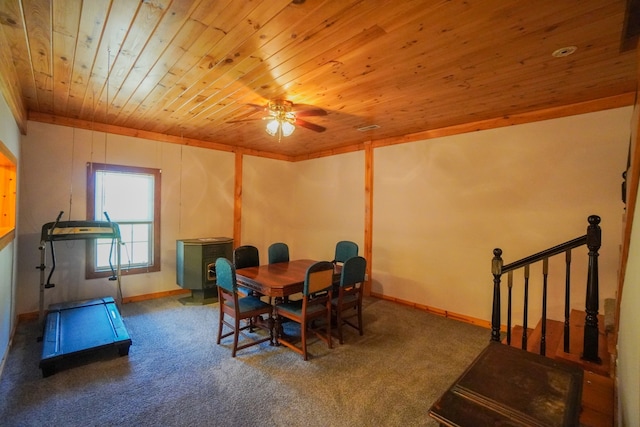 dining room featuring carpet, wood ceiling, a wood stove, and ceiling fan