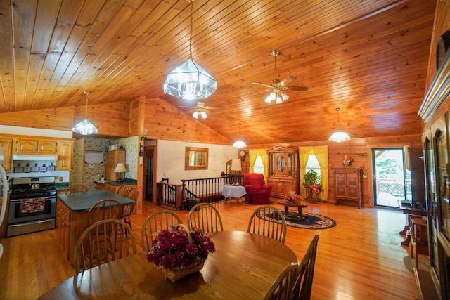 dining space with wood walls, light hardwood / wood-style flooring, high vaulted ceiling, and wooden ceiling