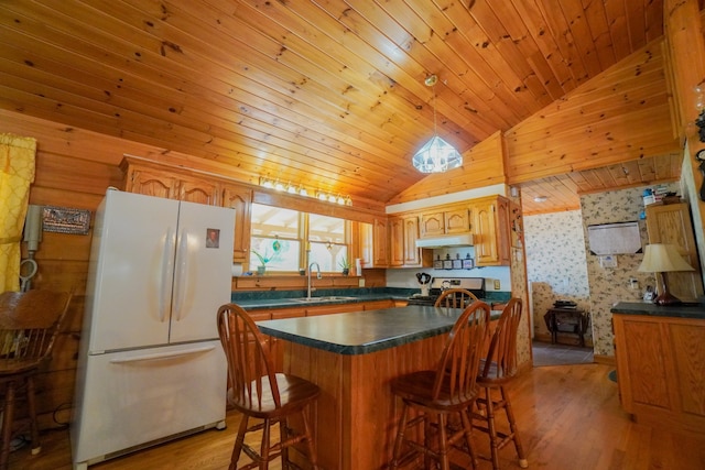 kitchen featuring electric range, light wood-type flooring, sink, a center island, and white refrigerator