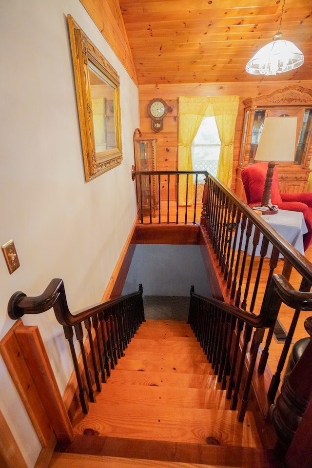 staircase with wood ceiling, hardwood / wood-style flooring, and lofted ceiling