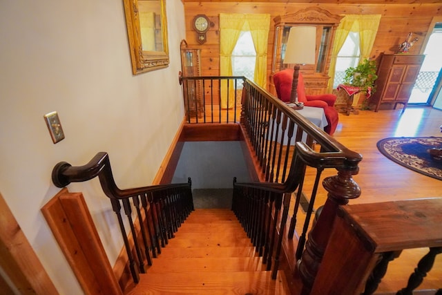 stairs featuring wood walls and hardwood / wood-style floors