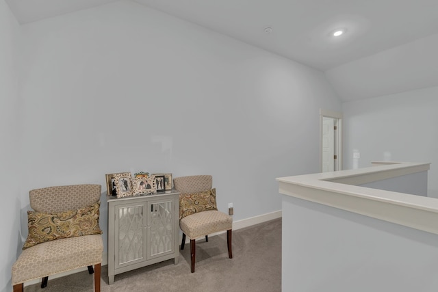 living area with light colored carpet and vaulted ceiling