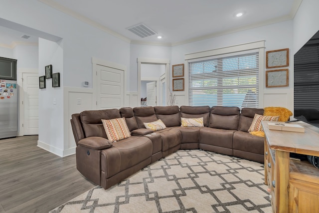 living room with wood-type flooring and crown molding