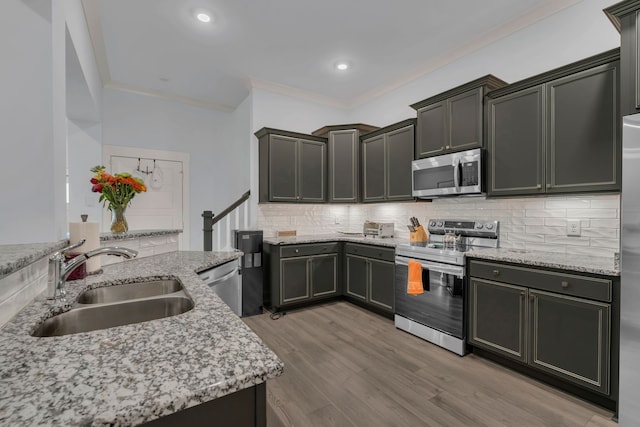 kitchen featuring light stone countertops, sink, and stainless steel appliances