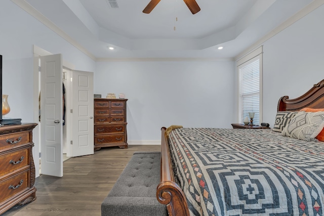 bedroom with a raised ceiling, ceiling fan, and dark wood-type flooring