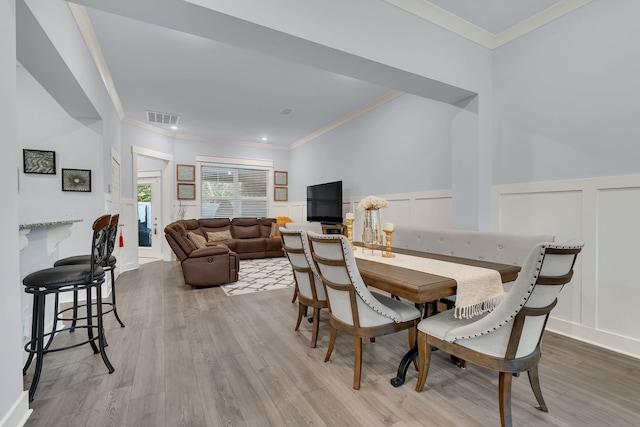 dining room featuring light hardwood / wood-style flooring and ornamental molding