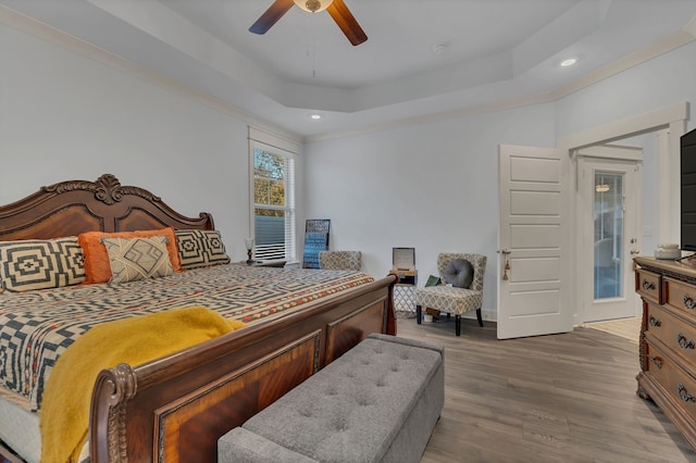 bedroom featuring a raised ceiling, ceiling fan, and hardwood / wood-style flooring