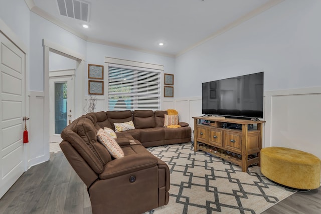 living room with hardwood / wood-style flooring and crown molding